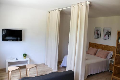 a bedroom with a bed with white curtains at Casal Do Crego in O Grove
