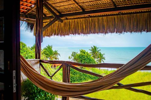 a hammock in a resort with a view of the ocean at Castelo Beach Hotel in Natal