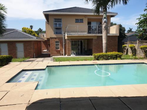 a swimming pool in front of a house at Malusi Bed and Breakfast in Verulam