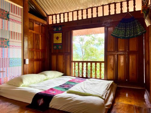 łóżko w pokoju z oknem w obiekcie An's House w mieście Hà Giang
