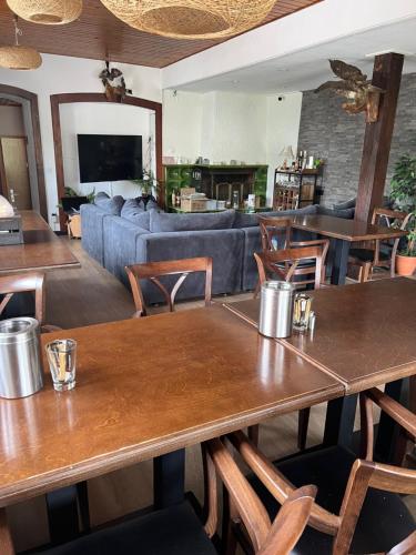 Pension Burgklause في Schönecken: مطعم بطاولات وكراسي وأريكة