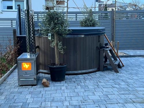 a hot tub sitting next to a tree in a fence at Pension Burgklause in Schönecken