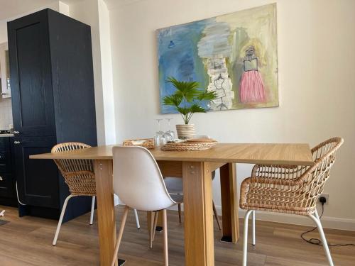 una mesa de comedor con sillas y una pintura en la pared en The Beach Box By Air Premier en Seaford