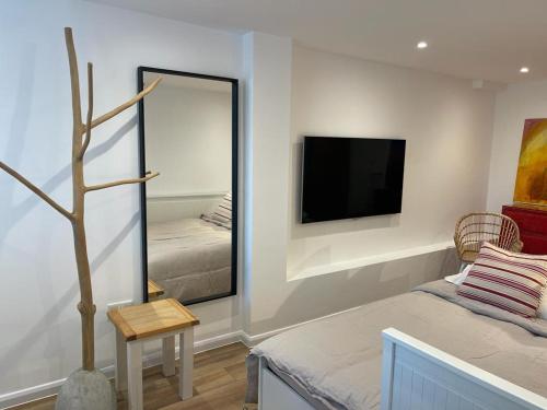 - un salon avec un miroir et une télévision dans l'établissement The Beach Box By Air Premier, à Seaford