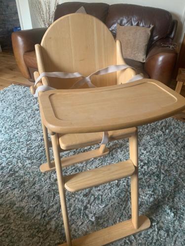 a wooden chair sitting in front of a couch at Hot tub breakaways with castle view in Lincolnshire