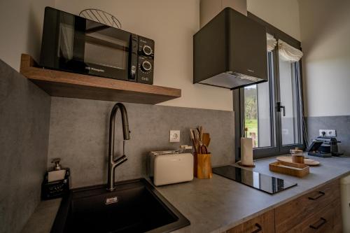 a kitchen with a sink and a microwave at Balarés Hotel da Natureza in Ponteceso