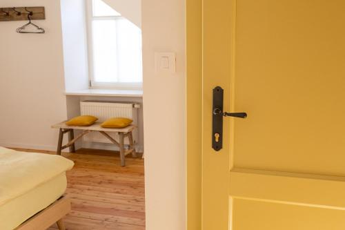 a yellow door in a bedroom with a table at Kotič na hribu in Dobravlje
