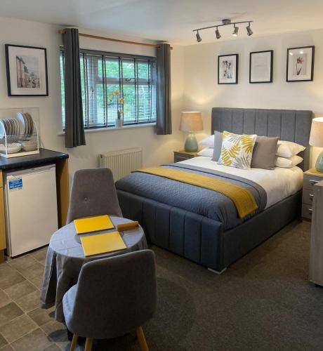 1 dormitorio con 1 cama, 1 silla y 1 mesa en Glaisdale Apartment en Wolverhampton