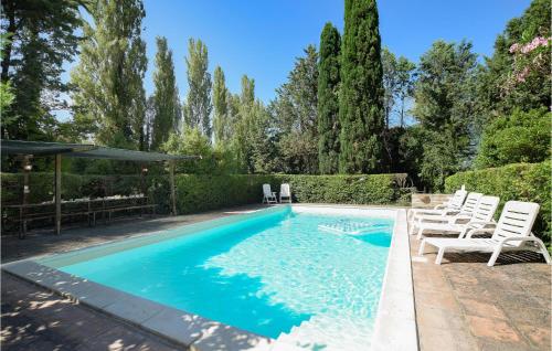 a swimming pool with white chairs and trees at Amazing Home In Rivotorto Di Assisi in Passaggio Di Assisi