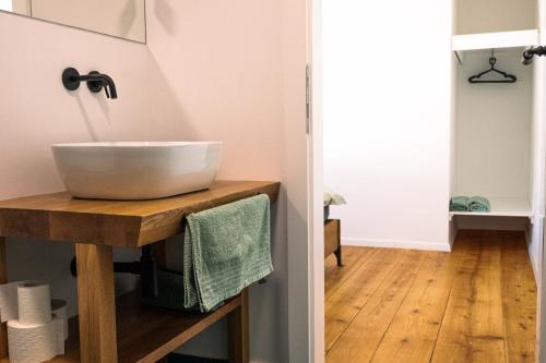 a bathroom with a white bowl sink on a wooden counter at Kotič na hribu in Dobravlje