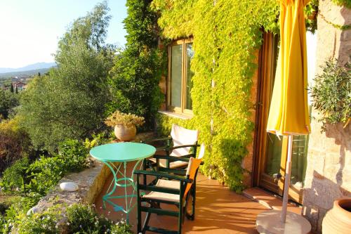 a patio with a table and chairs and an umbrella at Bio Guesthouse Mani Sonnenlink in Pírgos