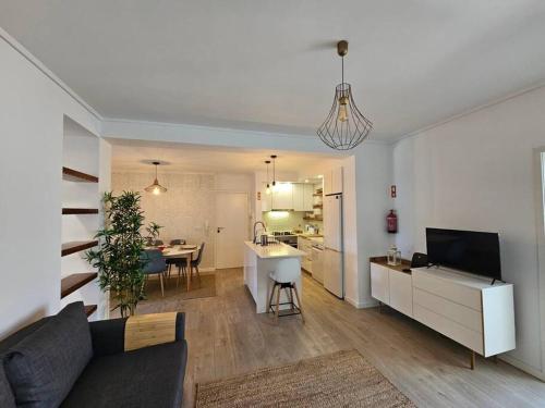 a living room and kitchen with a couch and a table at Ria Sol Mar Apartment Costa Nova in Costa Nova