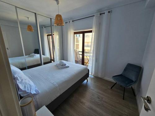 - une chambre avec un lit, une chaise et un miroir dans l'établissement Ria Sol Mar Apartment Costa Nova, à Costa Nova