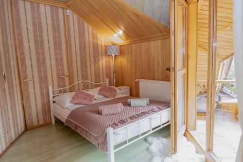 a bedroom with a bed with pink pillows on it at Willa Chruślice-Basen sezon,Sauna in Nowy Sącz