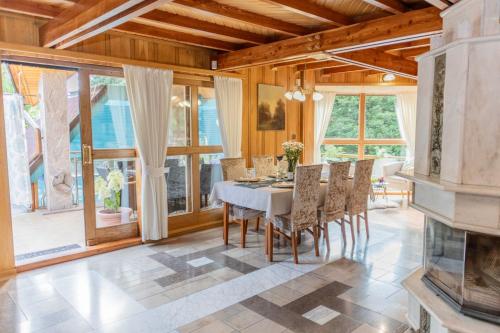 a dining room with a table and chairs and windows at Willa Chruślice-Basen sezon,Sauna in Nowy Sącz