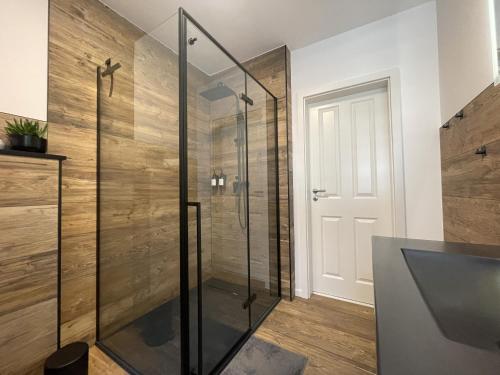 a glass shower in a bathroom with wooden walls at AR Apartments III I 4 Pers I Modern I Schillerapartment in Rudolstadt