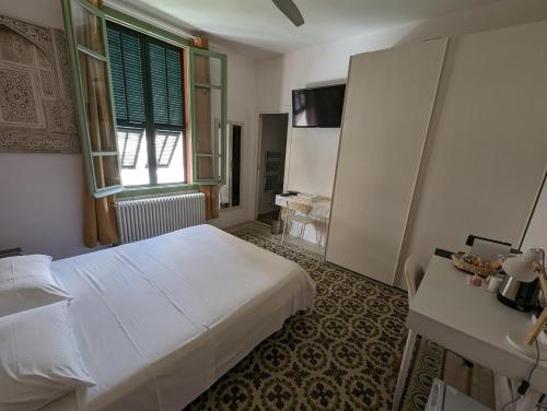 a bedroom with a white bed and a window at Villa Corsini in Laigueglia