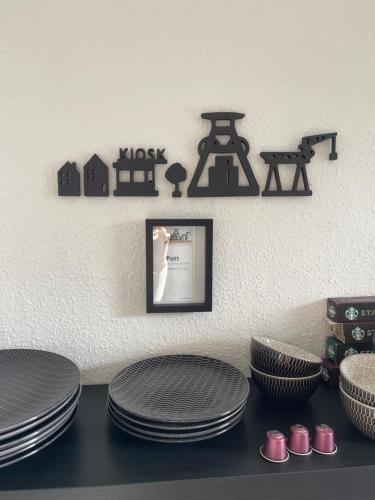 a table with plates and a picture on a wall at Caros Zimmer Gladbeck in Gladbeck