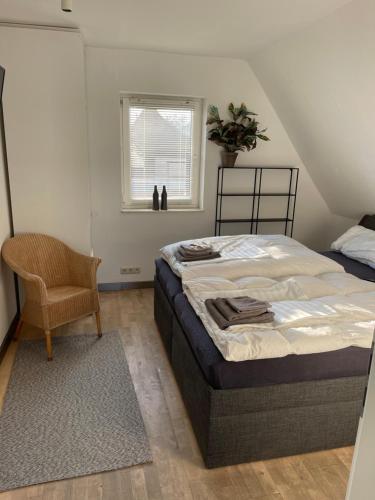a bedroom with a bed and a chair and a window at Caros Zimmer Gladbeck in Gladbeck