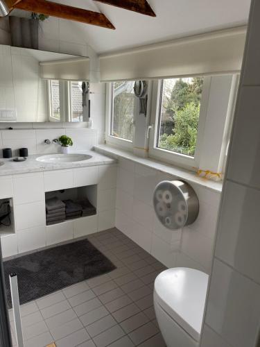 a white bathroom with a toilet and a sink at Caros Zimmer Gladbeck in Gladbeck
