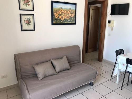 um sofá sentado numa sala de estar com uma mesa em Salento_Cala Acquaviva a Marina di Marittima (LE) em Marittima