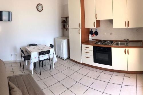 cocina con mesa, fregadero y nevera en Salento_Cala Acquaviva a Marina di Marittima (LE), en Marittima