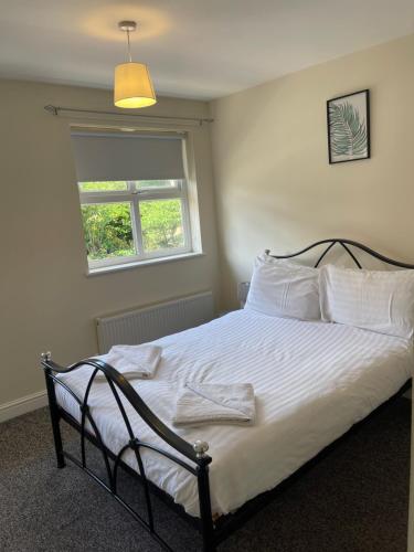 a bedroom with a bed with white sheets and a window at House number 4 Sleeps up to 5 with Smart TVs in every room in Wellington