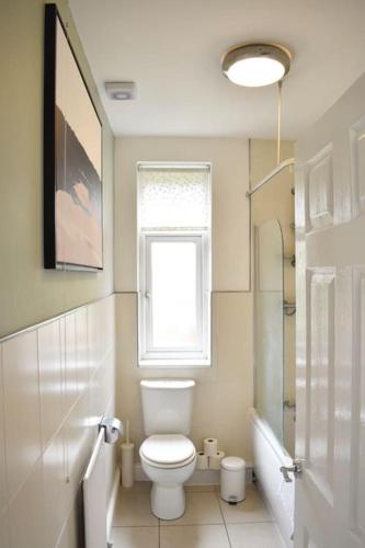 a white bathroom with a toilet and a window at 2 Bedroom Apartment in Gateshead in Gateshead