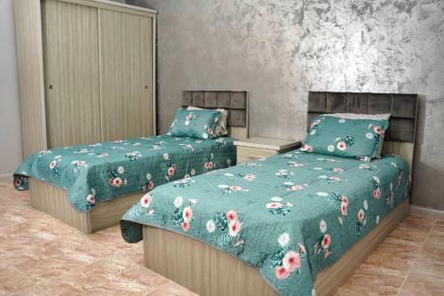 a bedroom with two beds with green comforters at Treasure of Petra in Wadi Musa