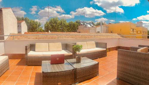 a rooftop patio with a table and chairs and a laptop at PENTHOUSE INDEPENDIENTE a 3 paradas en metro de ATOCHA (estacion central Madrid) in Madrid