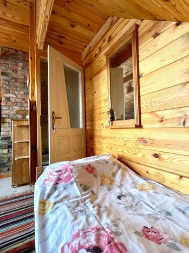 a bedroom with a bed in a wooden cabin at POLNA CHATA in Jasionówka