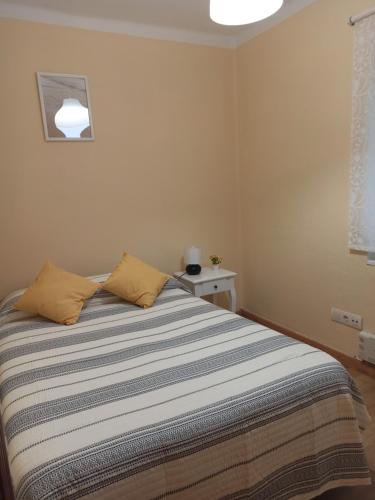 a bedroom with a bed with a striped blanket at Apartamento El Pórtico de Muros in Muros de Nalón