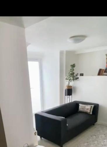 um sofá preto numa sala de estar com uma janela em Gravesend 1 Bedroom Flat 2 Min Walk to Station & Town Centre - longer stays available em Kent