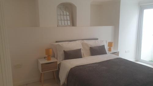 um quarto com uma cama e dois candeeiros numa mesa de cabeceira em Gravesend 1 Bedroom Flat 2 Min Walk to Station & Town Centre - longer stays available em Kent