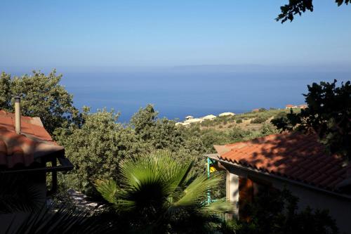 a view of the ocean from between two houses at Bio Guesthouse Mani Sonnenlink in Pírgos