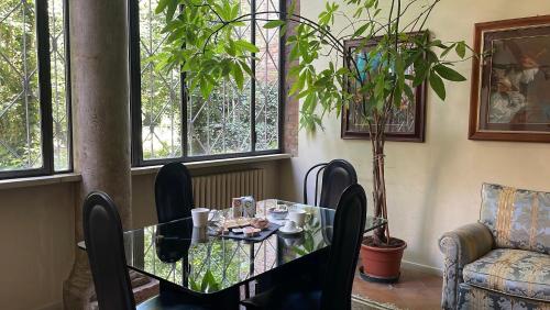 フェラーラにあるVizi e Virtùの窓付きの客室で、ガラスのテーブルと椅子が備わります。