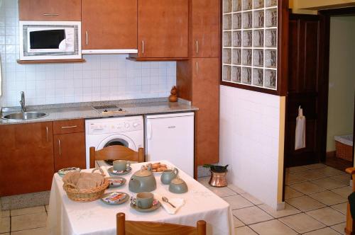a kitchen with a table with a white table cloth at Apartamentos Casa Germana in Tapia de Casariego