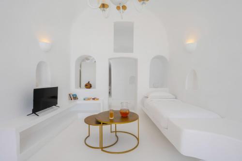 a white living room with a white couch and a table at Sophia Oia View in Oia