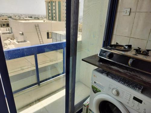 a washing machine in a room with a window at Prem Home Stay in Sharjah