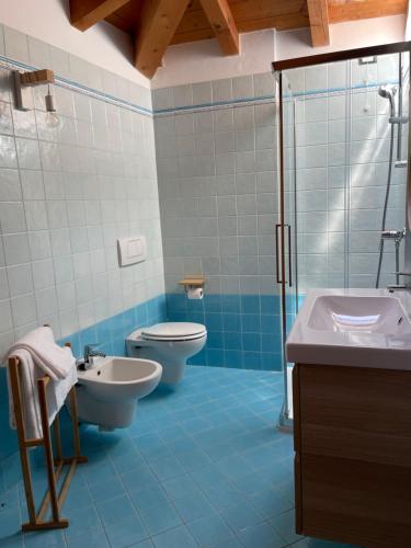 ein Badezimmer mit 2 WCs, einem Waschbecken und einer Dusche in der Unterkunft Ari’sNest in Caprino Veronese