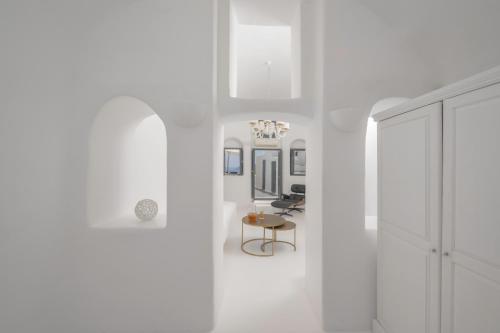 a hallway with white walls and a table in a room at Sophia Oia View in Oia