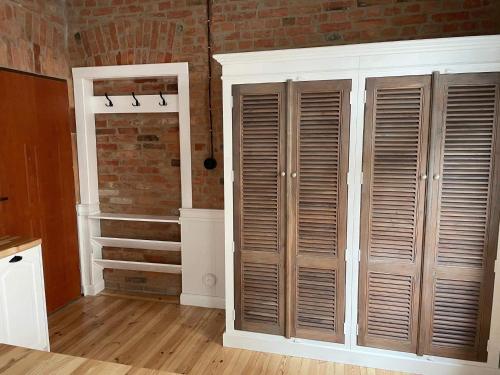 a room with wooden closets and a brick wall at Apartments PSD - Filmowa in Słupsk