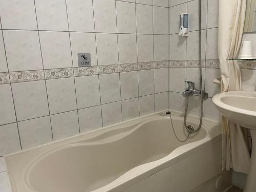 Yago Inn في تامسوي: حمام مع حوض استحمام ومغسلة