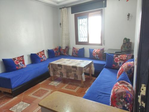 a living room with a blue couch and a table at Rabia ahayek in Chefchaouen