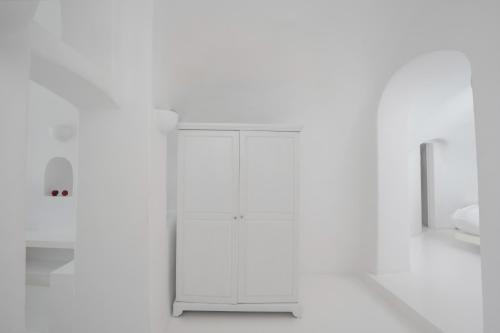 a white refrigerator in a room with white walls at Sophia Oia View in Oia