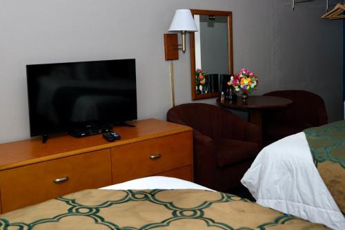 a room with a television on a dresser with a bed at Twi-Lite Inn in Front Royal