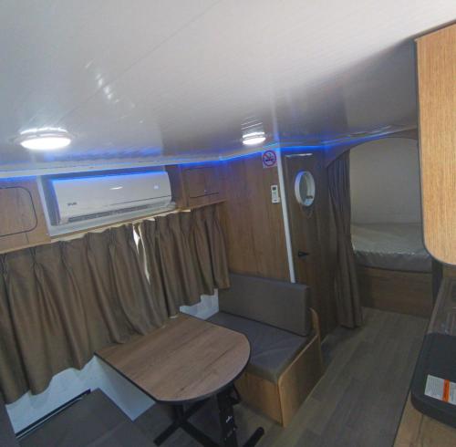 a small room with a table and a chair in an rv at האירוח המושלם בקטנה בקרוואן in Tel Aviv