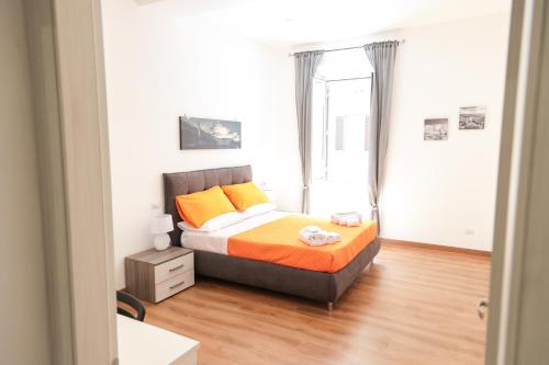 una camera da letto con un letto con cuscini arancioni e gialli di Trastevere Magic House Luxury Suite a Roma