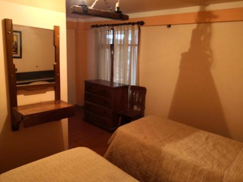 a bedroom with two beds and a mirror and a dresser at Cruz Popayan Sucre in Sucre