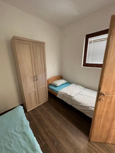 a small bedroom with a bed and a cabinet at Apartman Maja in Žabljak
